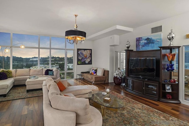 living room with dark hardwood / wood-style floors and an inviting chandelier