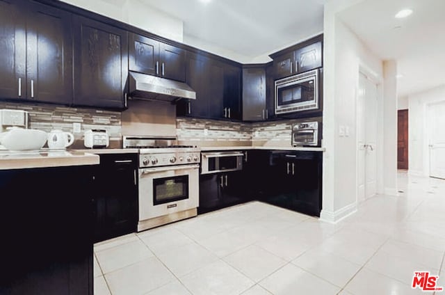 kitchen with backsplash, light tile patterned floors, and appliances with stainless steel finishes