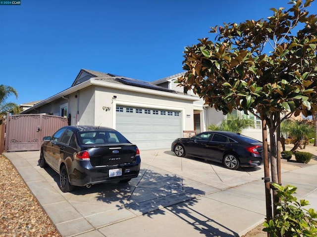 view of front facade featuring a garage and solar panels