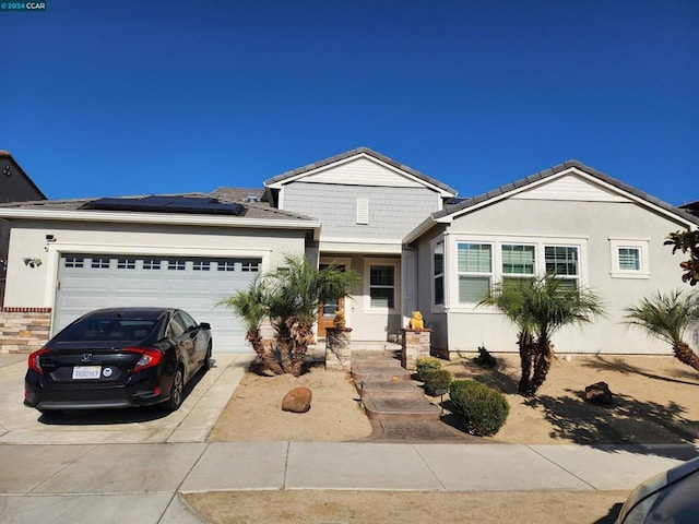 view of front of home with a garage and solar panels