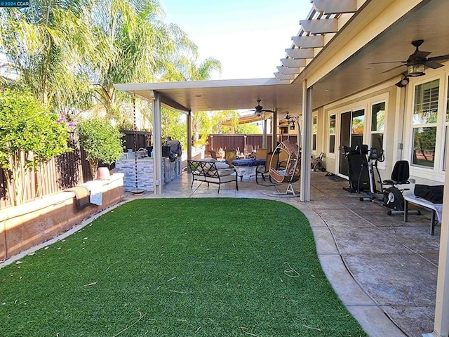 view of yard featuring ceiling fan, area for grilling, and a patio