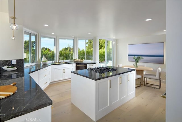 kitchen with light hardwood / wood-style flooring, white cabinets, plenty of natural light, and stainless steel gas cooktop