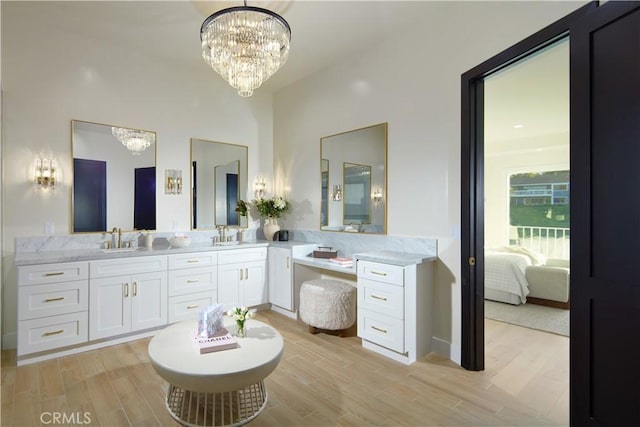 bathroom with hardwood / wood-style floors, vanity, and a notable chandelier