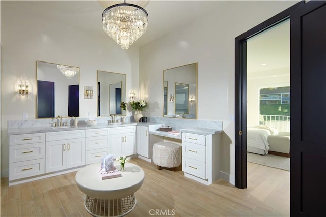 1 Rue Du Parc, Newport Beach, CA 92660 - bathroom featuring a chandelier, wood finished floors, double vanity, ensuite bathroom, and a towering ceiling