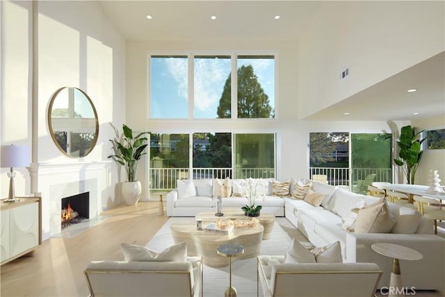 living room with a fireplace and a towering ceiling