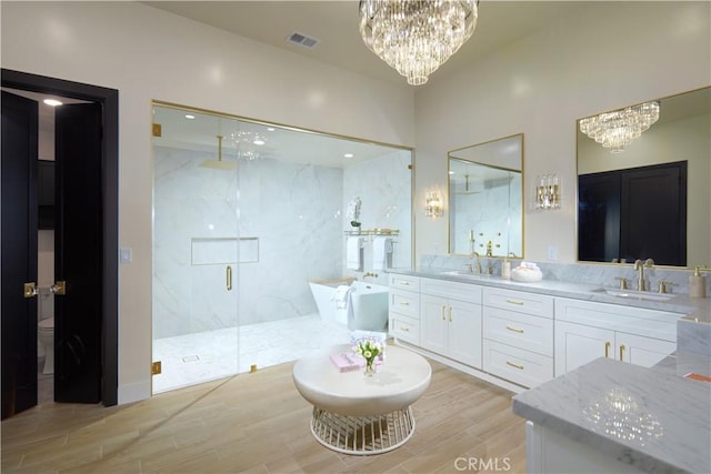 bathroom with shower with separate bathtub, vanity, and wood-type flooring