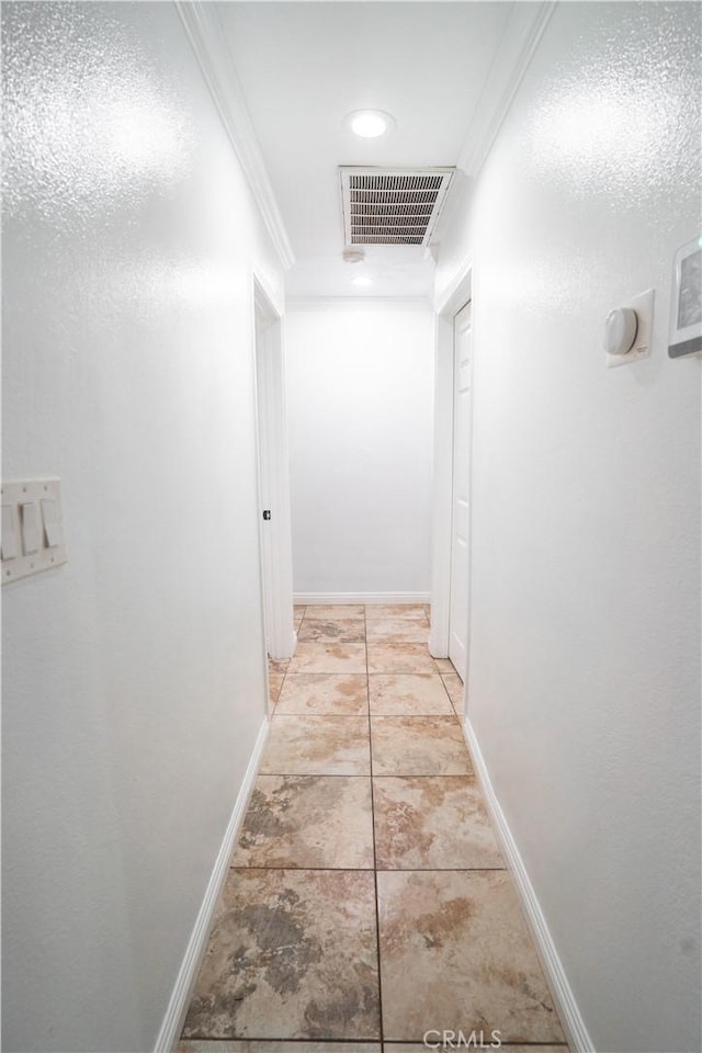 hall featuring light tile patterned floors and crown molding