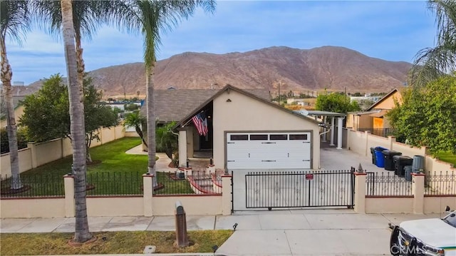 view of front of home featuring a mountain view, a garage, and a front lawn