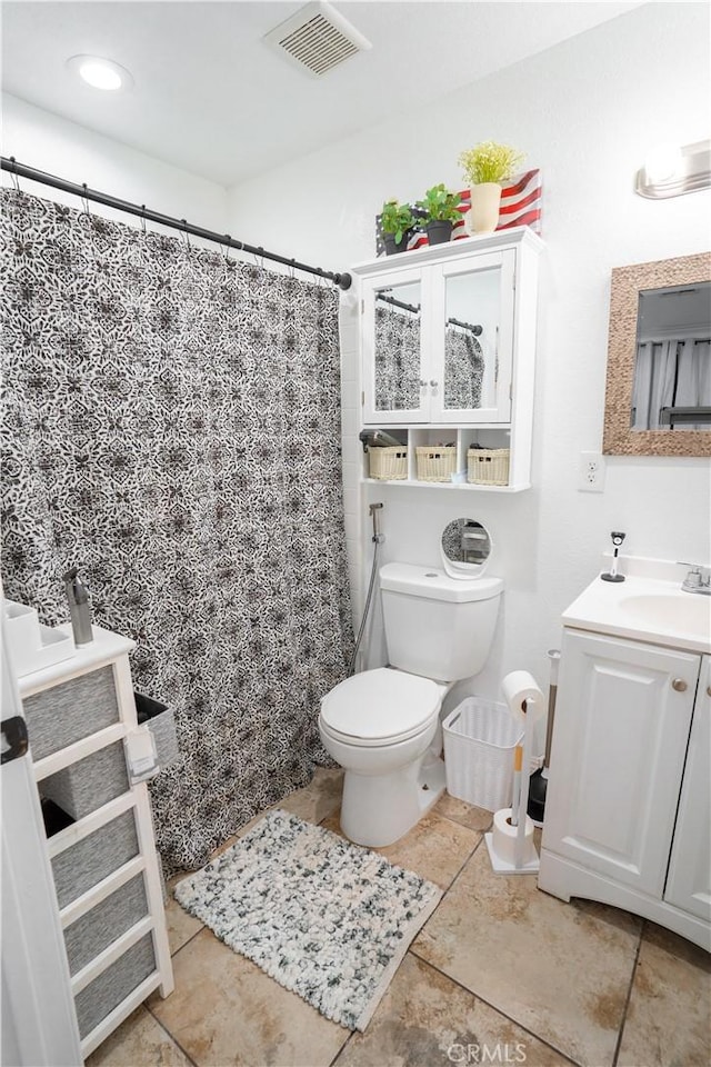 bathroom featuring tile patterned flooring, vanity, curtained shower, and toilet