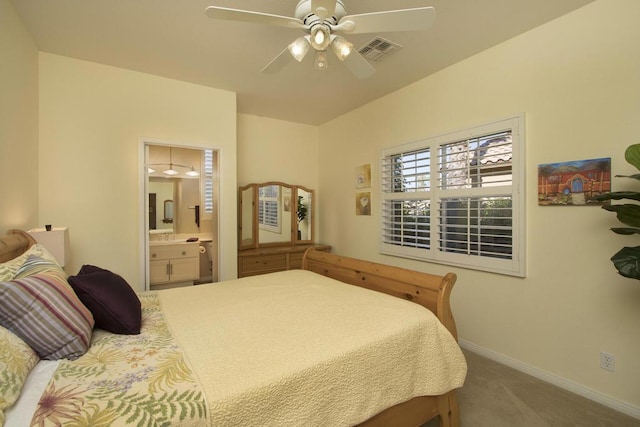 bedroom with ceiling fan, ensuite bathroom, and carpet