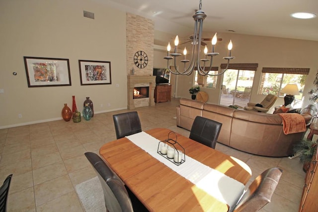 tiled dining room with a high ceiling, a fireplace, and an inviting chandelier