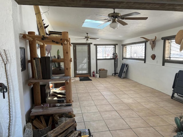 interior space featuring vaulted ceiling with skylight, ceiling fan, and a wealth of natural light