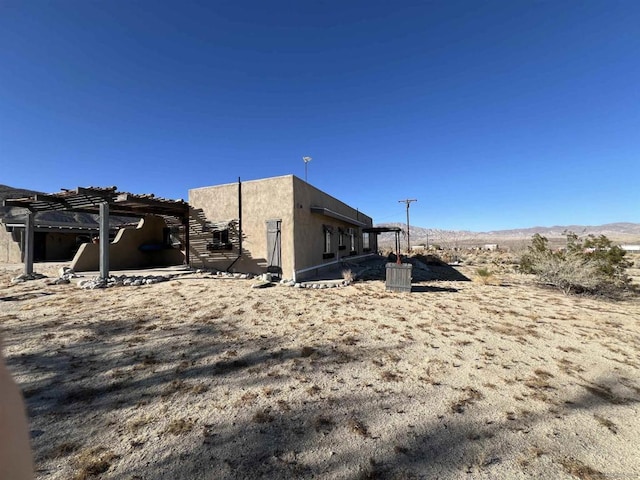 view of side of property featuring a mountain view and a pergola