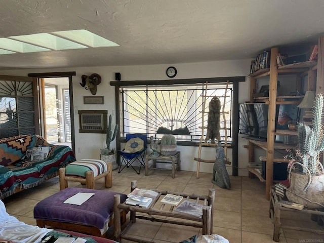 tiled living room with a skylight and a wall mounted air conditioner