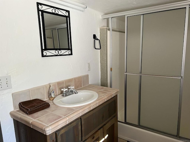 bathroom with vanity and enclosed tub / shower combo