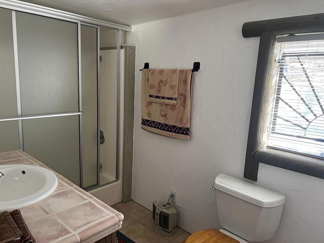 full bathroom featuring tile patterned floors, toilet, combined bath / shower with glass door, and vanity