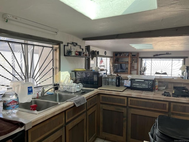 kitchen featuring tile countertops and sink