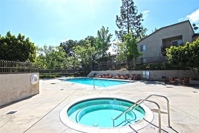 view of pool with a patio and a hot tub