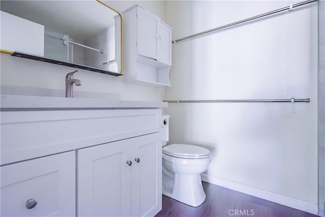 bathroom with hardwood / wood-style floors, vanity, and toilet