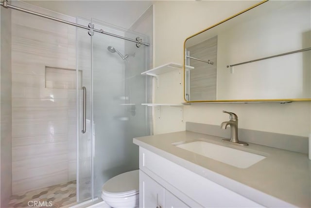 bathroom with vanity, a shower with shower door, and toilet