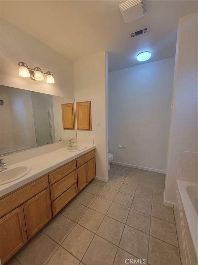 bathroom with tile patterned floors, a bathing tub, vanity, and toilet