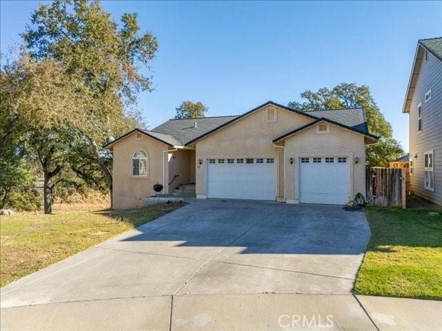 ranch-style home featuring a garage and a front lawn