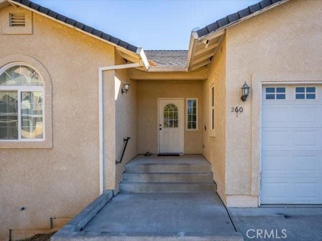 doorway to property with a garage