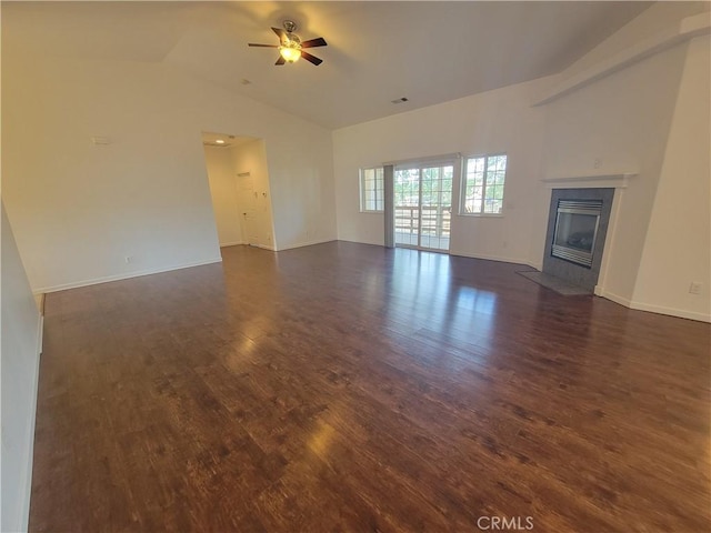 unfurnished living room featuring dark hardwood / wood-style flooring, vaulted ceiling, and ceiling fan