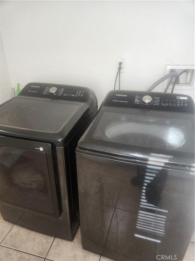 washroom featuring light tile patterned flooring and washing machine and clothes dryer