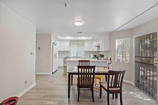 dining space featuring sink and light wood-type flooring