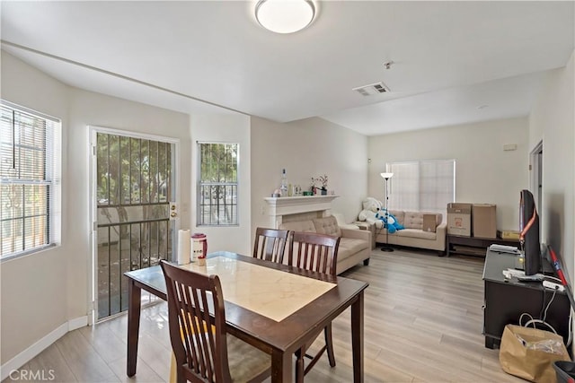 dining area with light hardwood / wood-style flooring and plenty of natural light