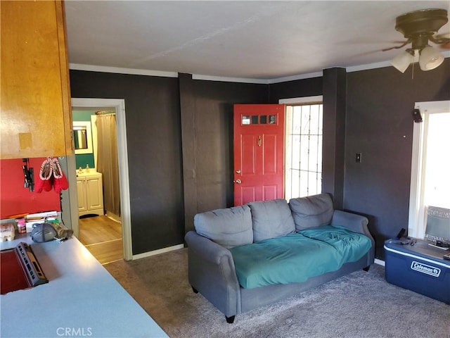 carpeted living room featuring ceiling fan and crown molding
