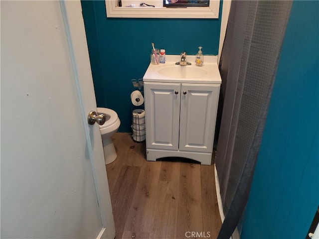 bathroom with vanity, hardwood / wood-style flooring, and toilet