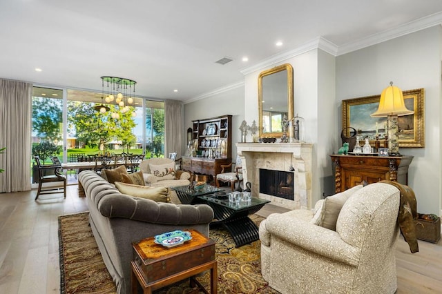 living room featuring a wall of windows, a fireplace, ornamental molding, and light wood-type flooring