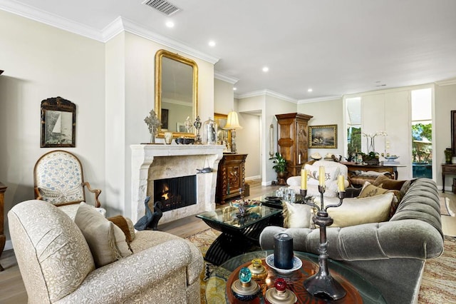 living room with crown molding, a fireplace, and hardwood / wood-style flooring