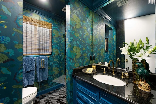 bathroom featuring toilet, vanity, and ornamental molding