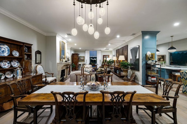 dining area with light hardwood / wood-style floors and crown molding