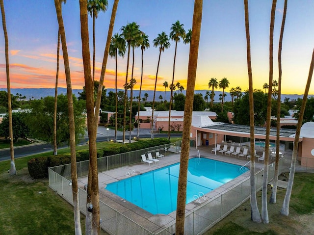 pool at dusk with a patio area