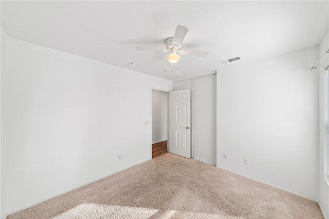 carpeted spare room with ceiling fan