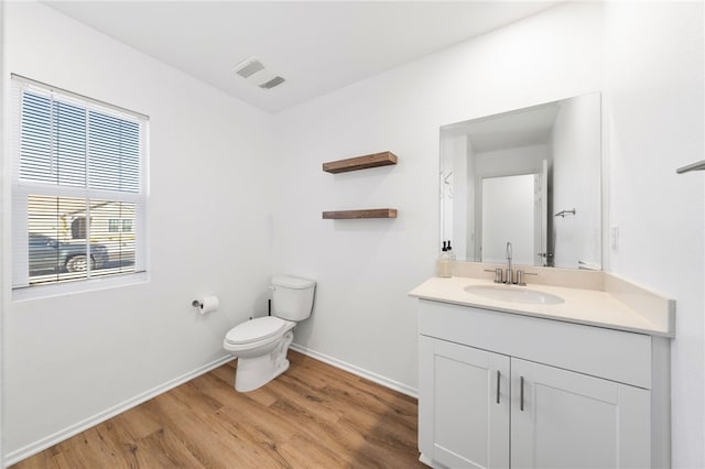 bathroom with hardwood / wood-style floors, vanity, and toilet