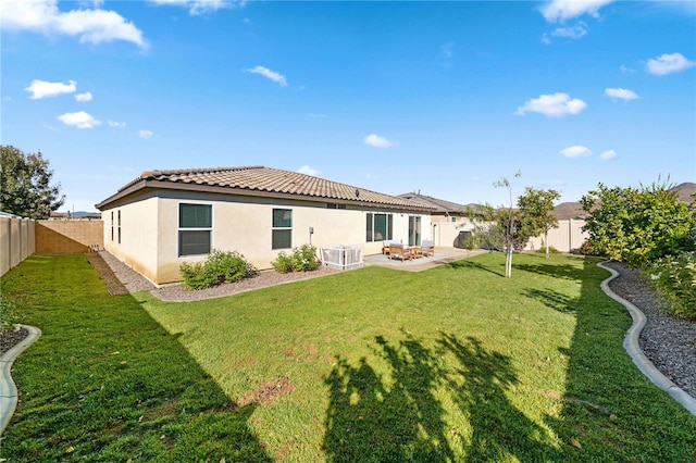 rear view of house featuring a patio and a lawn