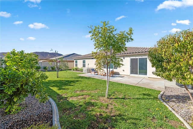 back of house featuring a mountain view, a patio area, and a lawn