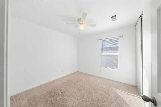 unfurnished room with ceiling fan and light carpet