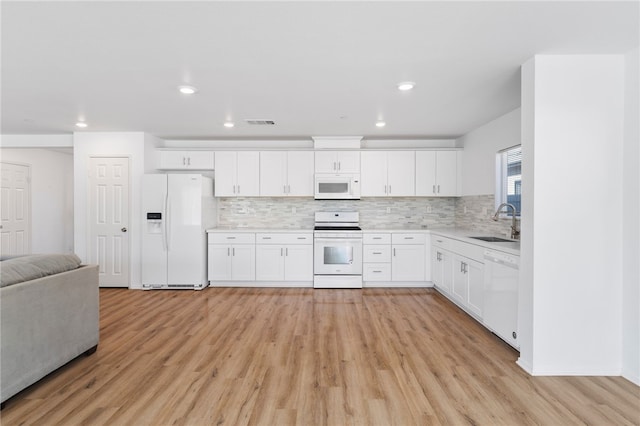 kitchen with white cabinetry, sink, light hardwood / wood-style floors, and white appliances