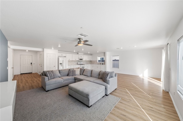 living room featuring light hardwood / wood-style floors and ceiling fan