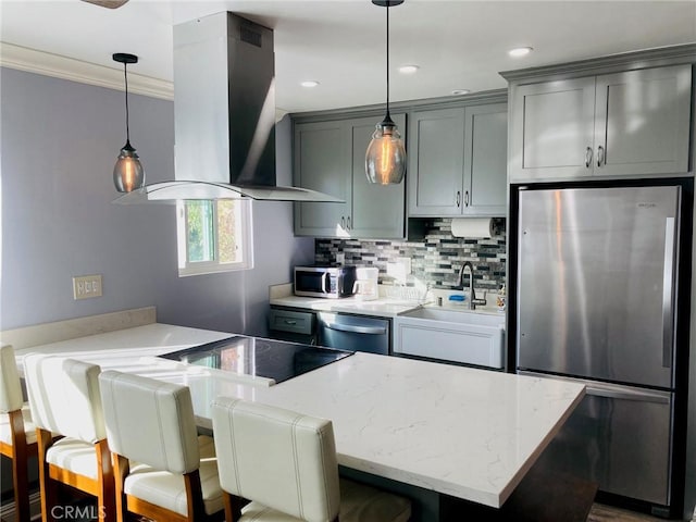 kitchen with ornamental molding, stainless steel appliances, island range hood, sink, and pendant lighting