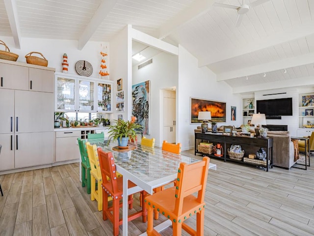 dining room with beam ceiling and high vaulted ceiling