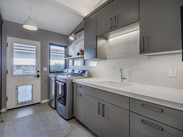 kitchen with pendant lighting, washing machine and dryer, decorative backsplash, and gray cabinetry