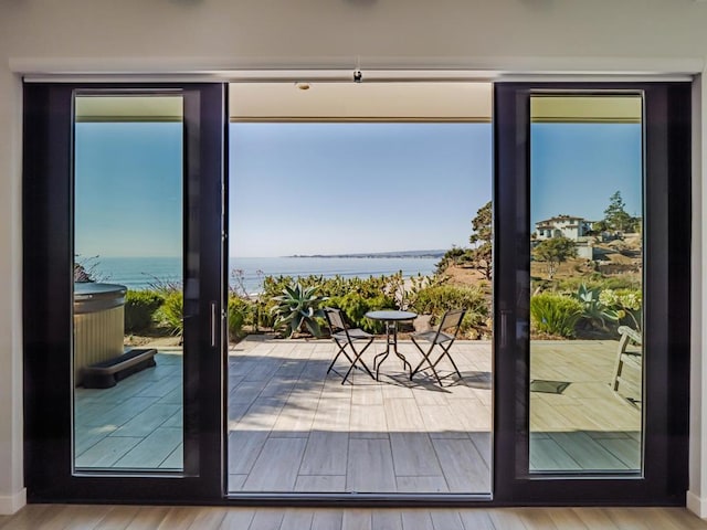 doorway to outside featuring hardwood / wood-style floors and a water view