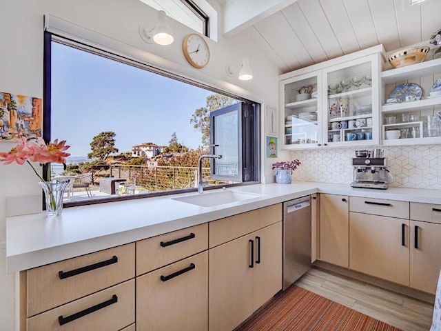 kitchen with light brown cabinetry, tasteful backsplash, dishwasher, sink, and light wood-type flooring